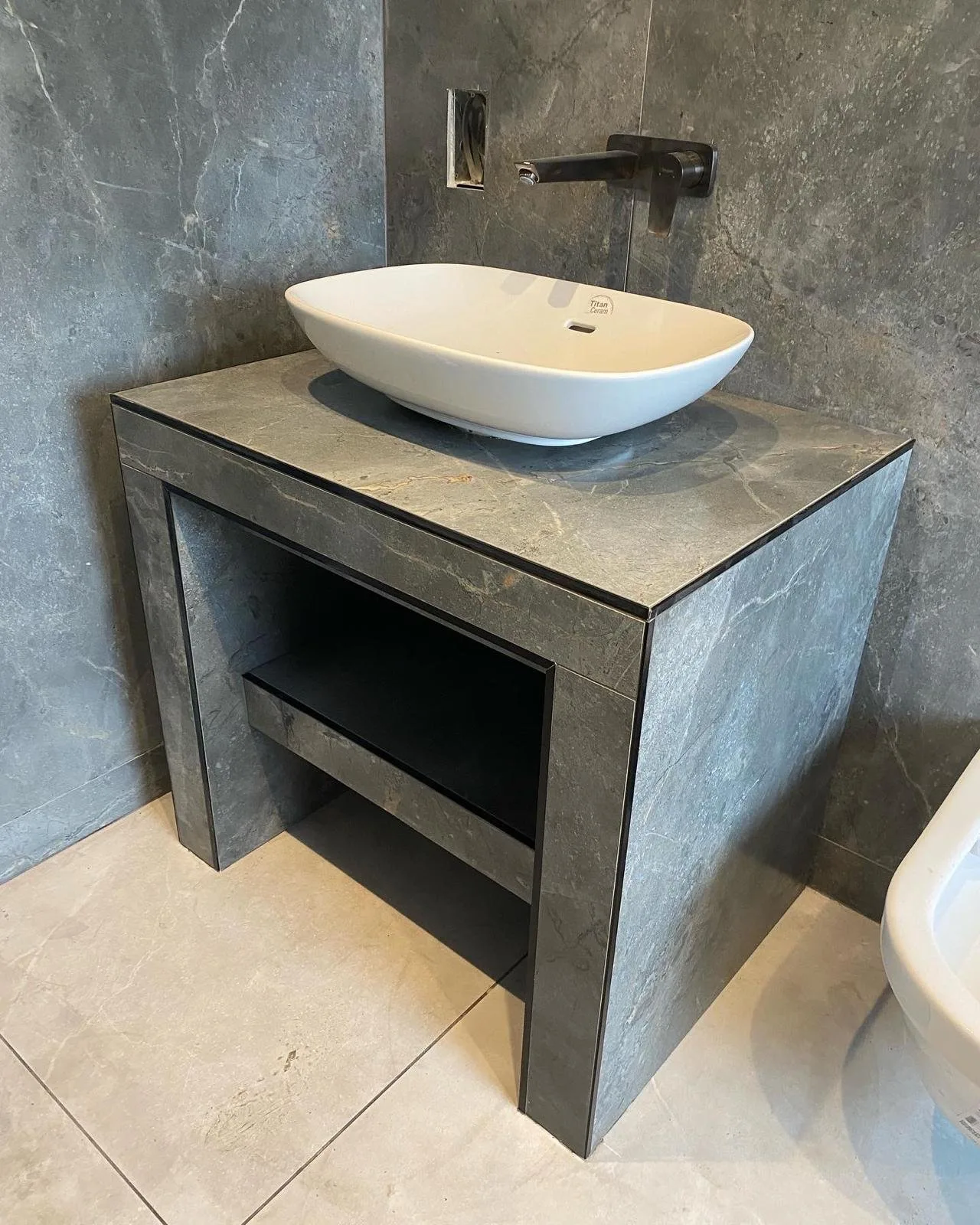 Bespoke stone-tiled vanity unit with countertop basin