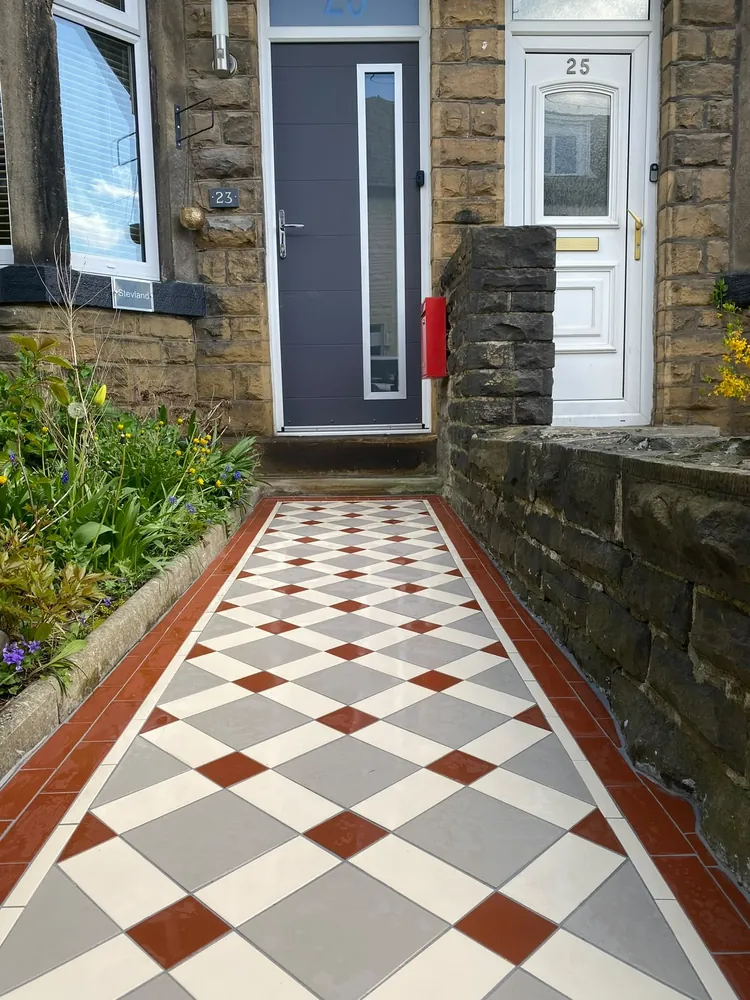 Red, grey and cream diamond Victorian tiled path leading to a stone terrace