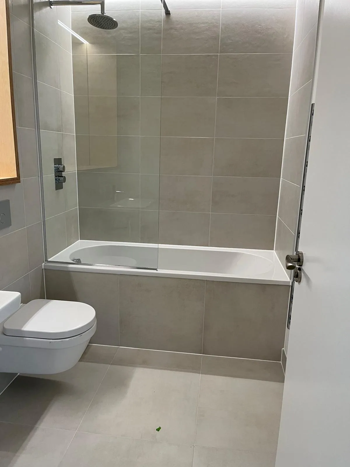 Modern bathroom with over-bath shower screen